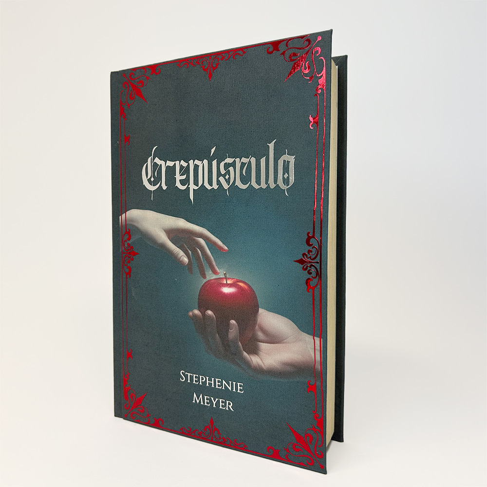Portada ilustrada de Crepúsculo con manzana roja y ornamentos metálicos
