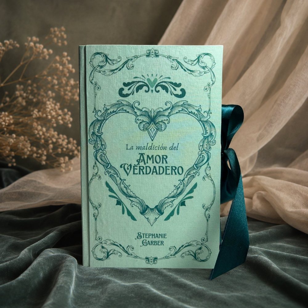 Cubierta de La Maldición del Amor Verdadero edición especial, en verde menta con la filigrana en forma de corazón